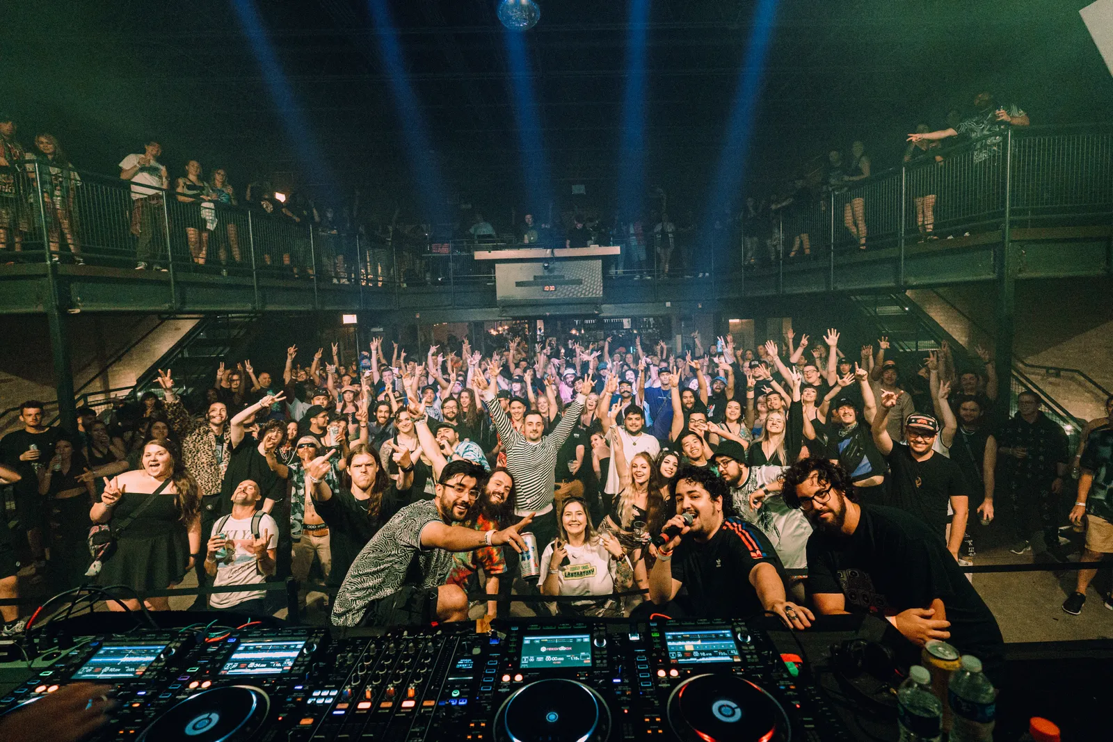 crowd with hands up seen from the dj booth